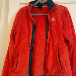 Orange fuzzy north face jacket